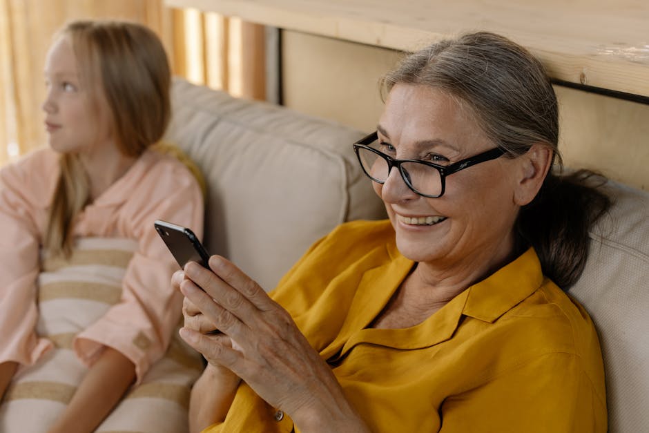 Senior woman in glasses smiling while using smartphone safely as she knows all about common online scams.