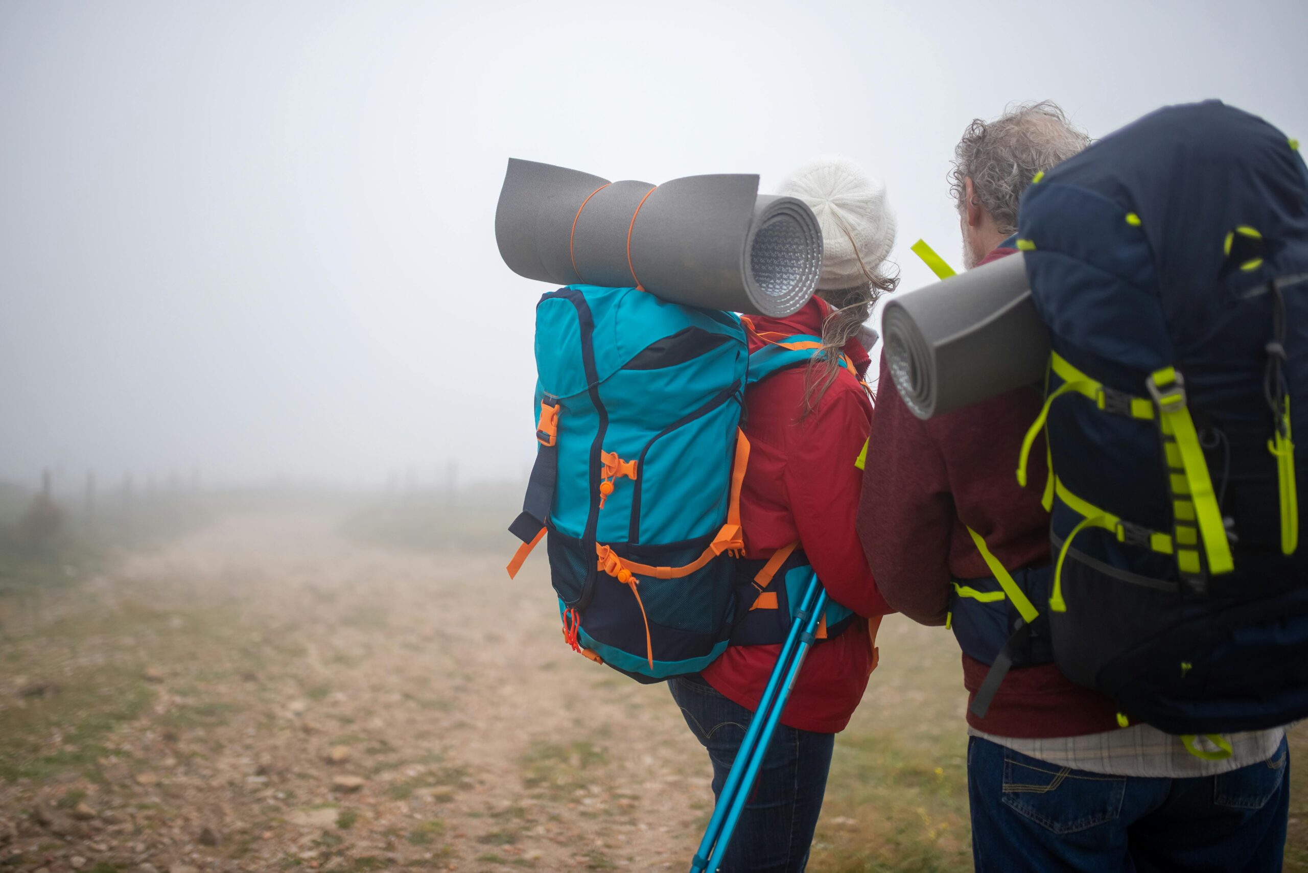 Senior couple hiking on a misty trail in Portugal, showcasing adventure and outdoor exploration.